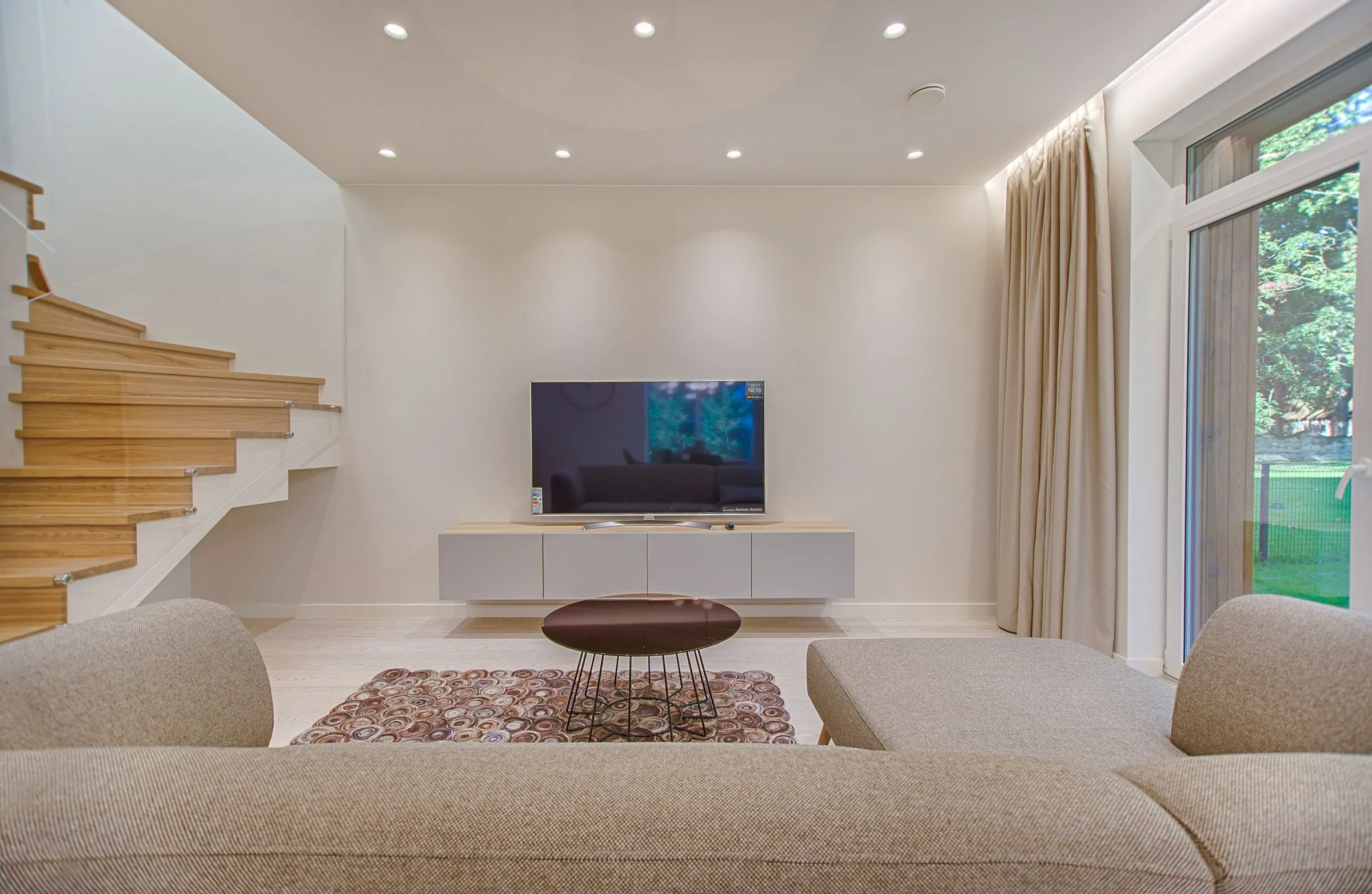 Modern living room with recessed lighting and open staircase